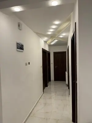 a hallway with white walls and brown doors at شقة مفروشه فاخرة للايجار الاردن عمان in Amman