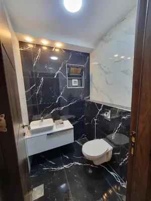 a bathroom with black marble walls and a toilet and sink at شقة مفروشه فاخرة للايجار الاردن عمان in Amman