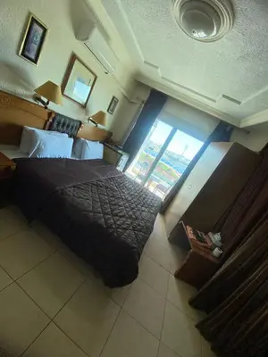 a bedroom with a large bed and a large window at CITYRISEHOTELINAMMAn in Al Jafr
