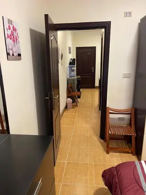 a hallway leading to a room with a kitchen and a door at Furnished one bedroom apartment in Amman