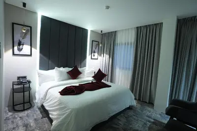 a bedroom with a large white bed with red pillows at Roya Downtown Boutique Hotel in Amman
