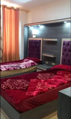 a bedroom with two beds with red sheets at Althemar Hotel Ajloun -Jordan By Enala Hotels Group in Ajloun
