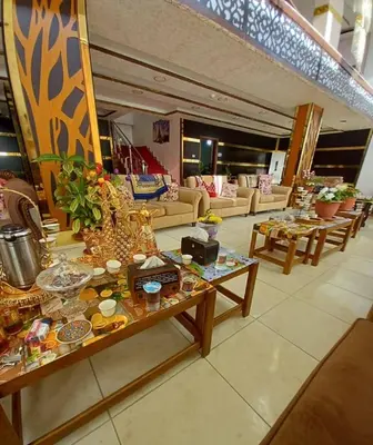 a living room with tables and couches in a building at Althemar Hotel Ajloun -Jordan By Enala Hotels Group in Ajloun
