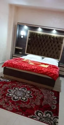 a bedroom with a bed and a red rug at Althemar Hotel Ajloun -Jordan By Enala Hotels Group in Ajloun