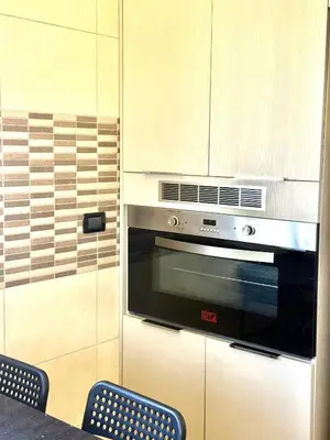 a kitchen with a stainless steel oven and two chairs at Luxury 2 Bedroom Apartment in Amman