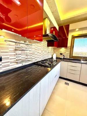 a kitchen with a black counter top and red ceilings at Luxury 2 Bedroom Apartment in Amman