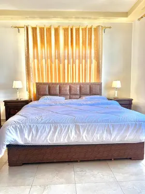 a bedroom with a large bed with blue sheets at Luxury 2 Bedroom Apartment in Amman