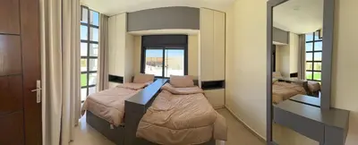 a bedroom with two beds and a mirror at Giving Vibes Chalet in Amman
