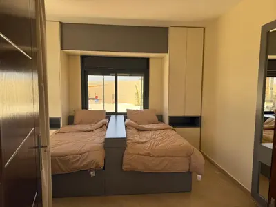 two beds in a small room with a window at Giving Vibes Chalet in Amman