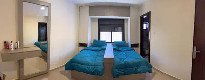 a bedroom with a bed with a large mirror at Giving Vibes Chalet in Amman