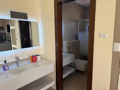 a bathroom with a sink and a toilet and a mirror at Giving Vibes Chalet in Amman