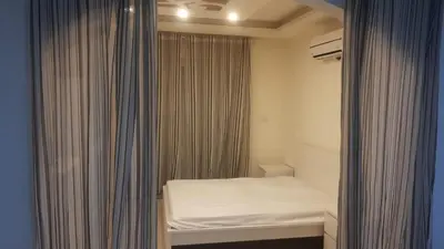 a small bedroom with a bed and a curtain at Al-Amaari Gardens Compound 3092 in Irbid