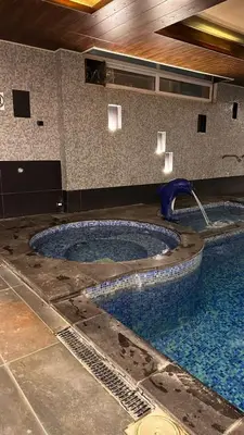 a swimming pool with a water fountain in a building at Al-Amaari Gardens Compound 3092 in Irbid