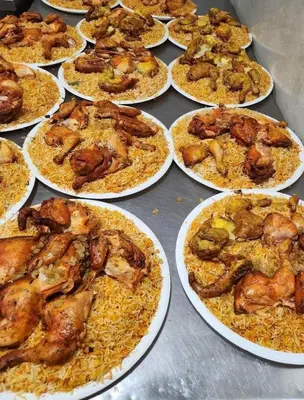 a bunch of pizzas with chicken and rice on plates at Tea apartment in Aqaba