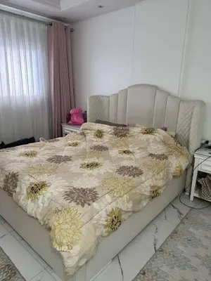a bedroom with a bed with a comforter on it at Tea apartment in Aqaba