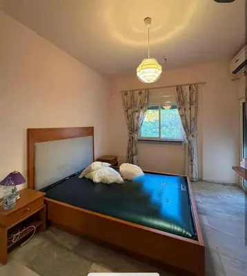 a bedroom with a large bed and a window at Tea apartment in Aqaba