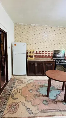 a kitchen with a table and a refrigerator at شقة مفروشة في عجلون in Ajloun