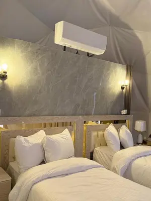 a bedroom with two beds with white pillows at Bubble Camp Wadi Rum in Wadi Rum