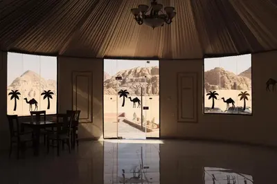 a dining room with a view of the desert and palm trees at Bubble Camp Wadi Rum in Wadi Rum