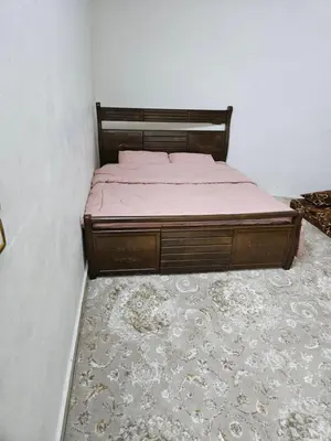 a bed sitting in a room with a rug at Rest & Relax Studio in Ajloun
