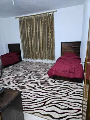 a bedroom with two beds and a zebra rug at Rest & Relax Studio in Ajloun