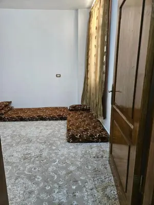 a room with two beds and a door at Rest & Relax Studio in Ajloun