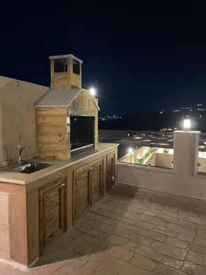 a kitchen with a sink on a rooftop at night at شاليهات إيليت بانوراما فيو in Jerash