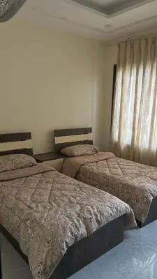 a bedroom with two beds and a window at شاليهات إيليت بانوراما فيو in Jerash