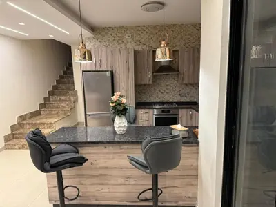 a kitchen with a counter and two stools at Bahama-Oriya chalets in Al Rama