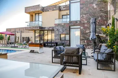 a patio with chairs and an umbrella next to a building at Bahama-Oriya chalets in Al Rama