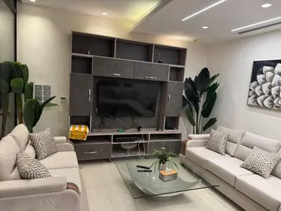 a living room with a large entertainment center with a television at Bahama-Oriya chalets in Al Rama