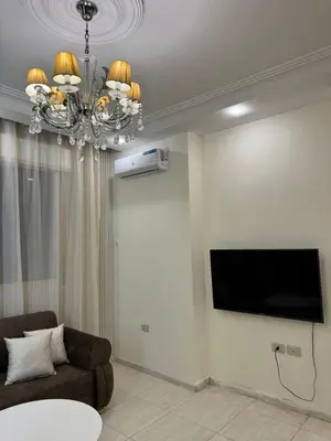 a living room with a couch and a flat screen tv at stay by university of Jordan in Amman