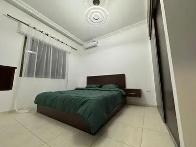 a bedroom with a bed in a white room at stay by university of Jordan in Amman