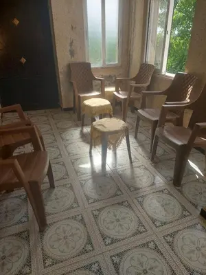 a waiting room with chairs and a table and a table sidx sidx at عجلون in Ajloun