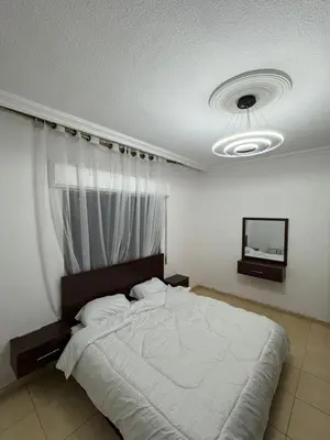 a bedroom with a large bed and a television at stay by university of Jordan in Amman
