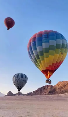 two hot air balloons flying in the sky at Celestial Mirage Camp in Wadi Rum