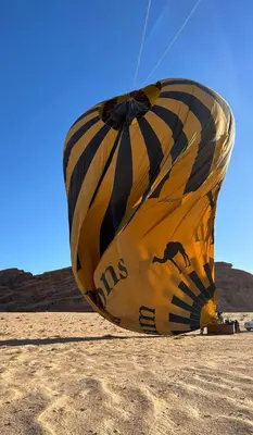 a large yellow and black kite sitting in the sand at Celestial Mirage Camp in Wadi Rum