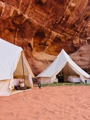 two white tents in front of a cliff at The Legacy of Wadi Rum in Wadi Rum