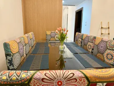 a table with chairs and a vase of flowers on it at Loom & Light In the best location in Abdoun Amman in Amman