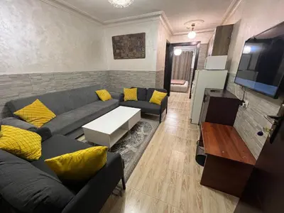 a living room with a couch and a tv at Central modern affordable studio in Amman