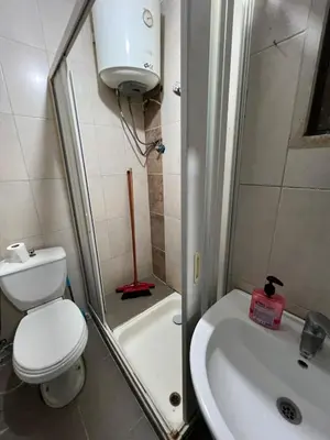 a small bathroom with a toilet and a sink at Central modern affordable studio in Amman