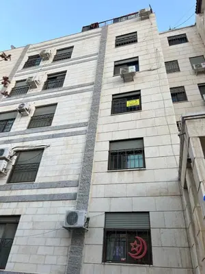 a tall brick building with windows and a sign on it at Central modern affordable studio in Amman