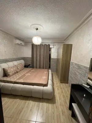 a bedroom with a bed and a couch in it at Central modern affordable studio in Amman