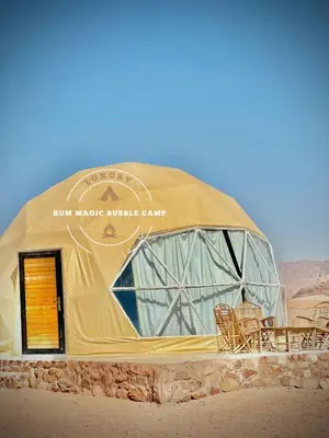 a large dome building with chairs in the desert at RUM MAGIC BUBBLE lUXURY CAMP in Wadi Rum