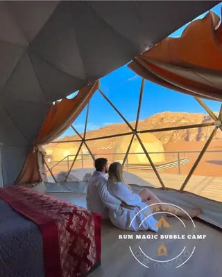 a couple sitting in a tent looking out at the desert at RUM MAGIC BUBBLE lUXURY CAMP in Wadi Rum
