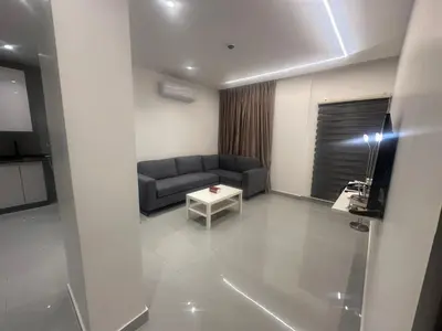 a living room with a couch and a table at Masaken Hotel Apartment in Amman