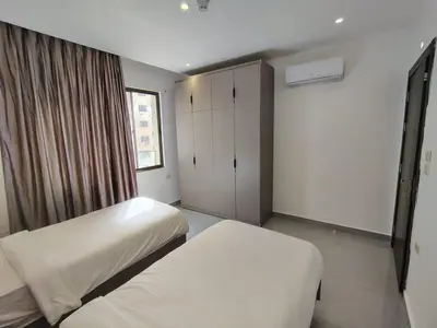 a bedroom with two beds and a window at Masaken Hotel Apartment in Amman