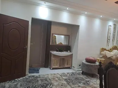 a bathroom with a sink and a mirror at شقة مميزة in Rujm Maghghijhah