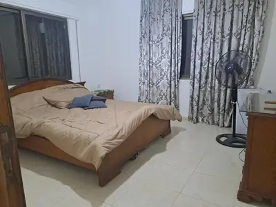 a bedroom with a bed in a room with windows at شقة مميزة in Rujm Maghghijhah