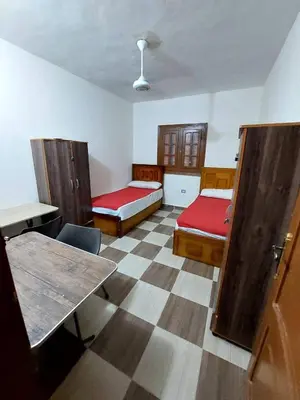 a room with two beds and a table in it at Ok apartment in Petra